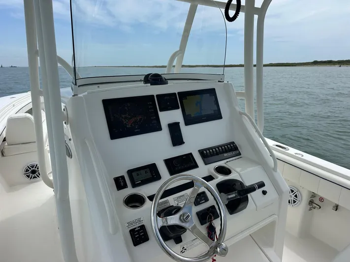  Yacht Photos Pics 2016 Regulator center console boat dashboard with navigation screens and steering wheel on open water.