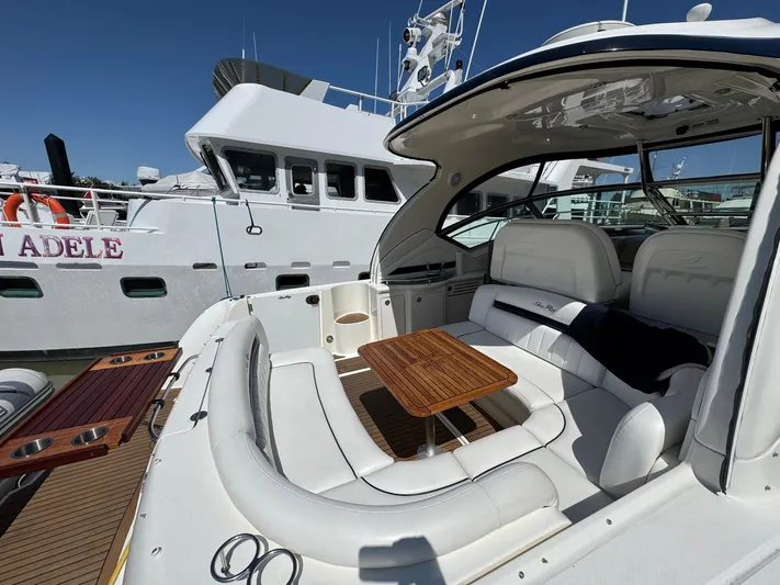  Yacht Photos Pics 2007 Sea Ray 400 Sundancer yacht with white seating and wooden table, docked beside another vessel.