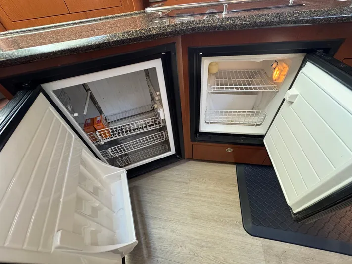  Yacht Photos Pics Open refrigerators in 2007 Sea Ray 400 Sundancer yacht kitchen, showcasing storage space.