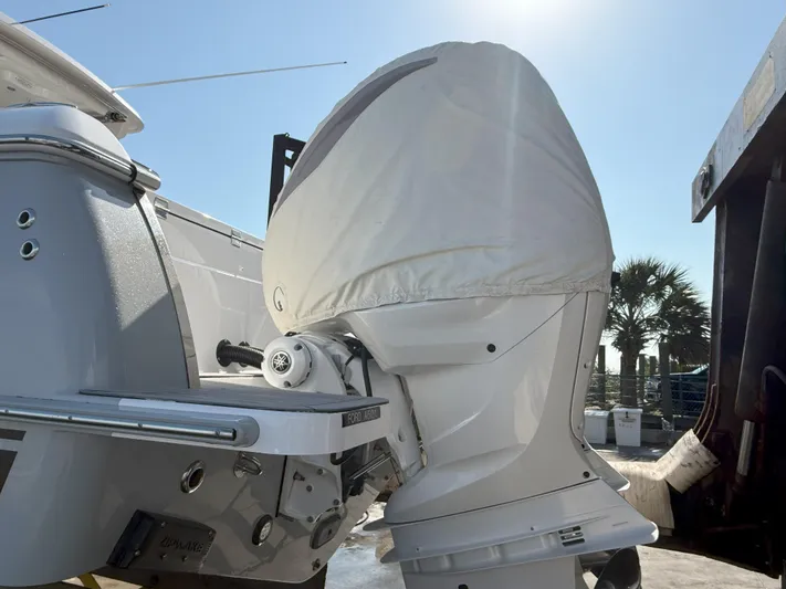 Yacht Photos Pics 2022 Southport 33 DC boat engine with protective cover in sunny marina setting.
