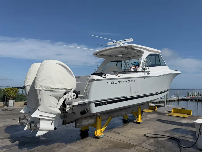  Yacht Photos Pics 2022 Southport 33 DC boat on dock with twin engines, clear sky background.