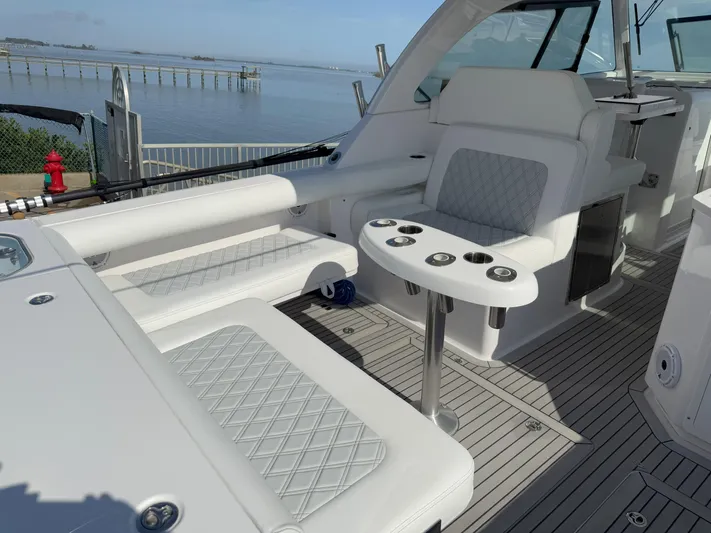 Yacht Photos Pics 2022 Southport 33 DC boat interior with white seating and table, overlooking calm waters.