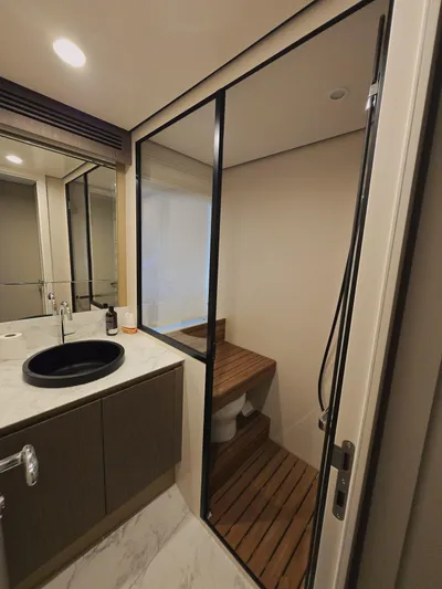 Yacht Photos Pics Luxurious bathroom in 2024 Azimut Magellano 60 yacht with modern fixtures and wooden accents.