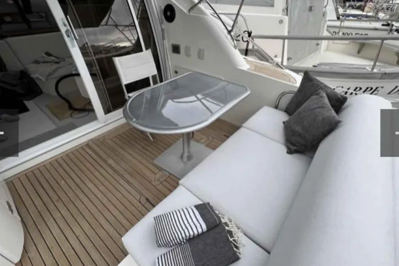 Ocilo Yacht Photos Pics Luxurious 2005 Sealine SC 39 yacht deck with sofa, table, and cushions.