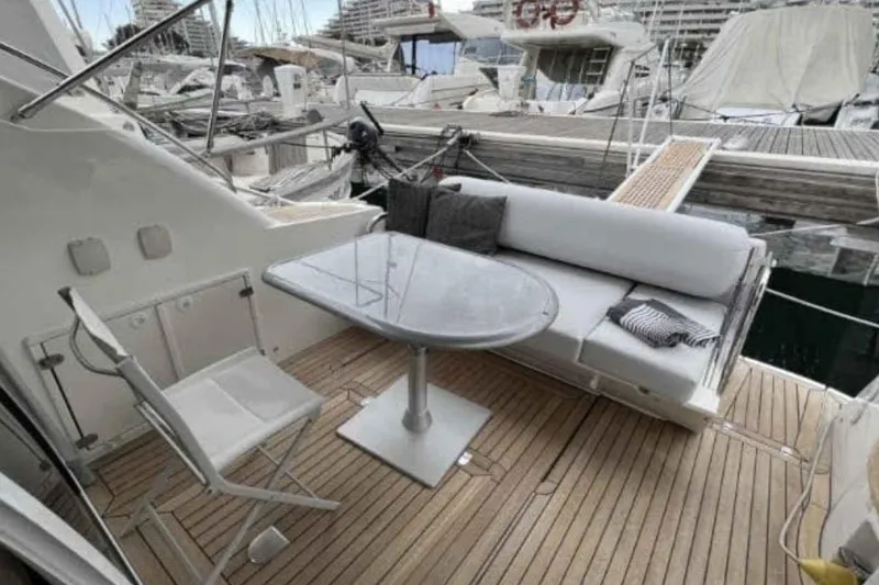 Ocilo Yacht Photos Pics 2005 Sealine SC 39 yacht deck with seating and table, docked in marina.