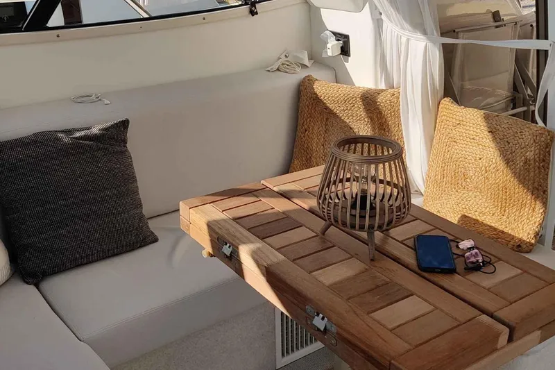 Ocilo Yacht Photos Pics Interior of 2005 Sealine SC 39 yacht with cozy seating and wooden table.