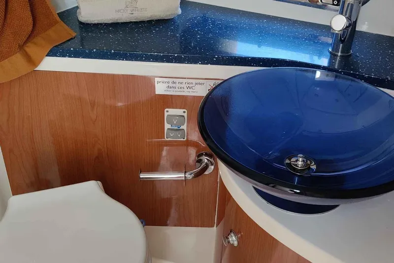 Ocilo Yacht Photos Pics 2005 Sealine SC 39 yacht bathroom with blue glass sink and wooden cabinetry.