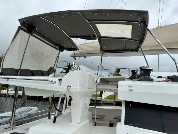 Cerebral Seabatical Yacht Photos Pics 2019 Fountaine Pajot Saona 47 yacht helm station with canopy, docked near water.