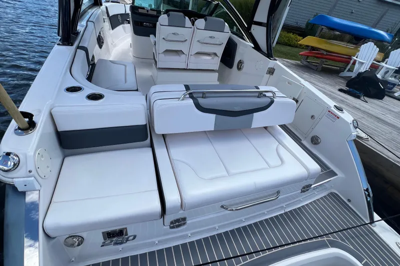  Yacht Photos Pics 2020 Chaparral 280 OSX boat interior with white seating and cup holders by the water.