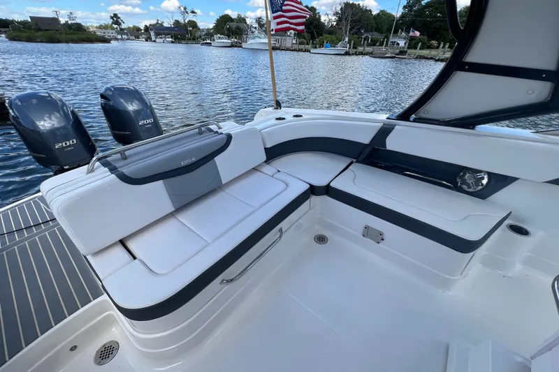  Yacht Photos Pics 2020 Chaparral 280 OSX boat interior with seating and dual outboard engines on a scenic waterway.
