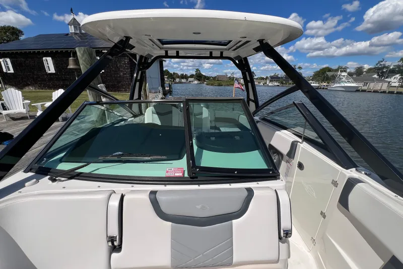  Yacht Photos Pics 2020 Chaparral 280 OSX boat docked by a scenic waterfront with clear skies.