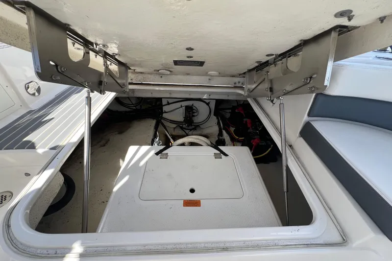  Yacht Photos Pics 2020 Chaparral 280 OSX boat storage compartment with open hatch and visible mechanical components.