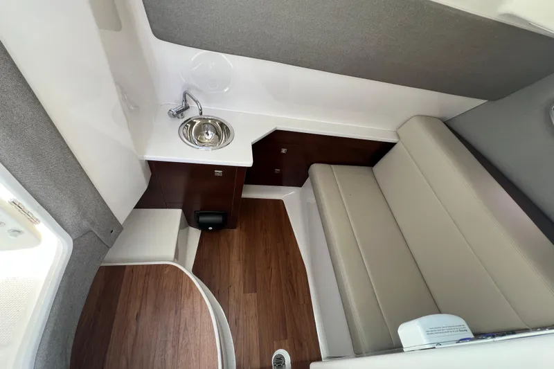  Yacht Photos Pics 2020 Chaparral 280 OSX interior with sink, seating, and wood flooring.