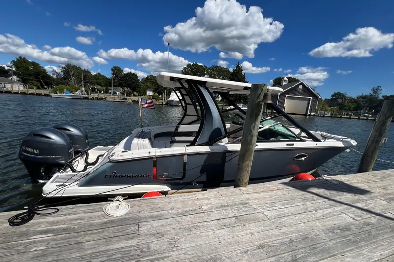  Yacht Photos Pics 2020 Chaparral 280 OSX boat docked by a wooden pier under a clear blue sky.