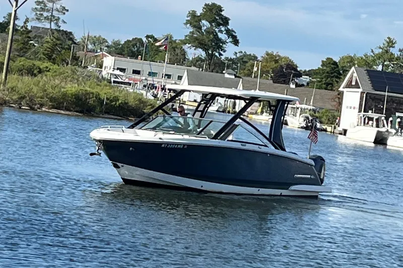  Yacht Photos Pics 2020 Chaparral 280 OSX boat cruising on a calm river near a marina.