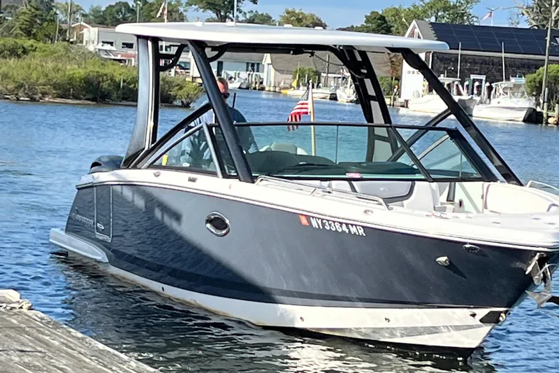  Yacht Photos Pics 2020 Chaparral 280 OSX boat on water near dock, American flag visible.