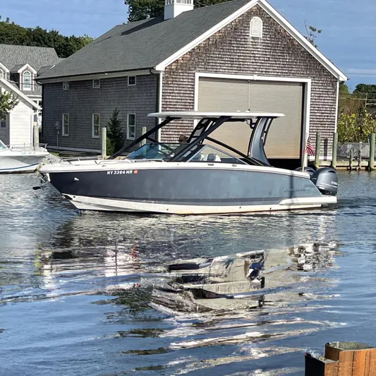 Yacht Photos Pics 2020 Chaparral 280 OSX boat docked near a wooden boathouse.