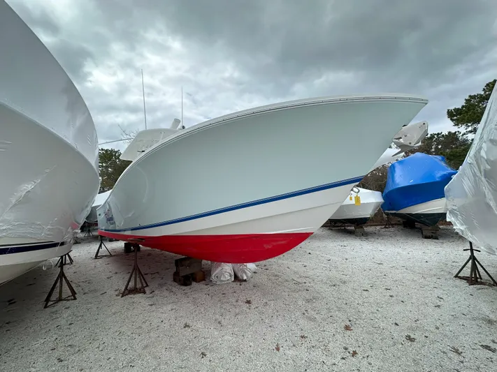 Angler Management Yacht Photos Pics 2013 Regulator 34 Center Console boat with red hull, stored outdoors.