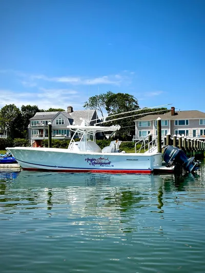 Angler Management Yacht Photos Pics 2013 Regulator 34 Center Console boat docked by waterfront homes under clear blue sky.