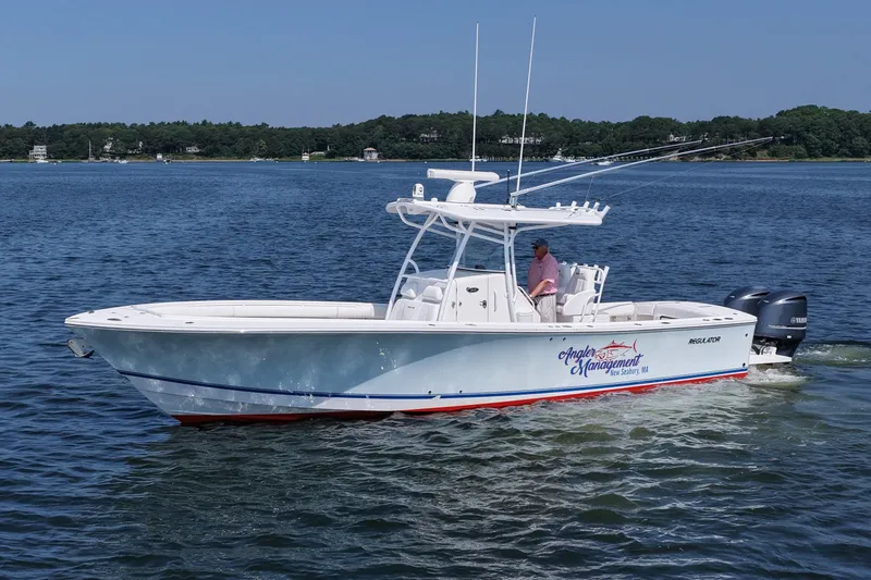 Angler Management Yacht Photos Pics 2013 Regulator 34 Center Console boat cruising on a calm lake.