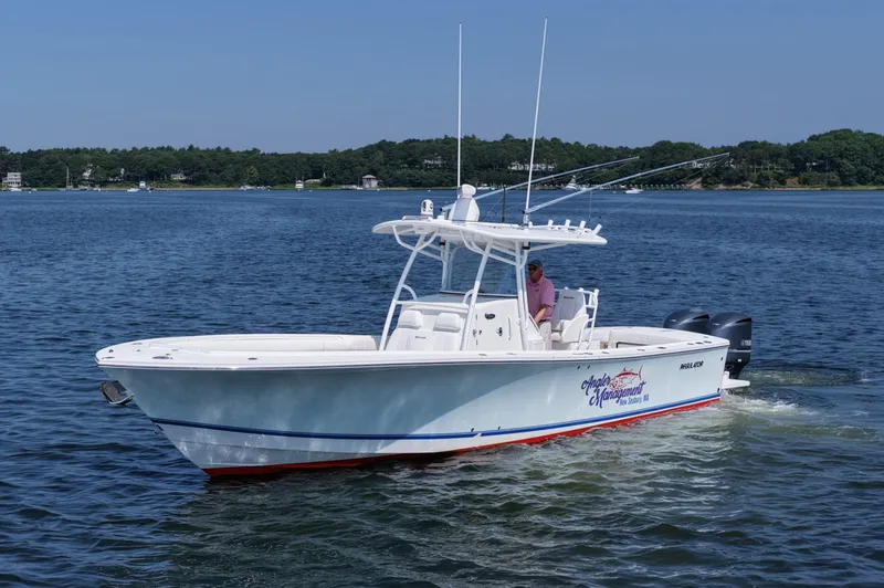 Angler Management Yacht Photos Pics 2013 Regulator 34 Center Console boat cruising on a calm lake with scenic background.