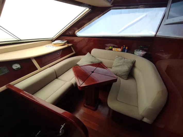  Yacht Photos Pics Luxurious interior of 2005 Posillipo Technama 80 yacht with plush seating and wooden table.