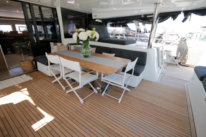  Yacht Photos Pics Luxurious 2019 Lagoon 620 Essense yacht deck with dining area and elegant floral centerpiece.