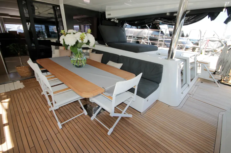  Yacht Photos Pics Luxurious 2019 Lagoon 620 Essense yacht deck with dining area and elegant seating.