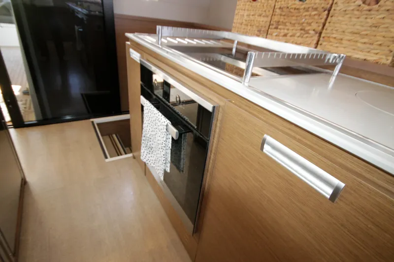  Yacht Photos Pics Modern kitchen interior of 2019 Lagoon 620 Essense yacht with sleek wooden cabinetry.