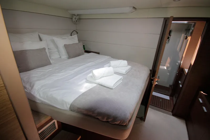  Yacht Photos Pics Luxurious bedroom interior of 2019 Lagoon 620 Essense yacht with neatly arranged bed and towels.