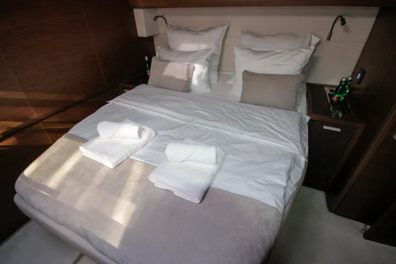  Yacht Photos Pics Luxurious cabin interior of 2019 Lagoon 620 Essense yacht with neatly arranged bed linens.