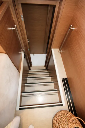  Yacht Photos Pics Staircase inside 2019 Lagoon 620 Essense yacht with wooden finish and storage compartments.
