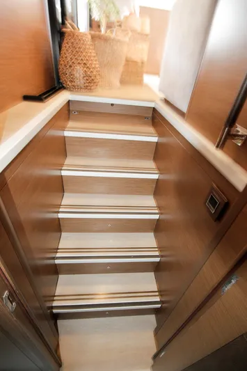  Yacht Photos Pics Staircase inside 2019 Lagoon 620 Essense yacht with wooden finish and modern design.