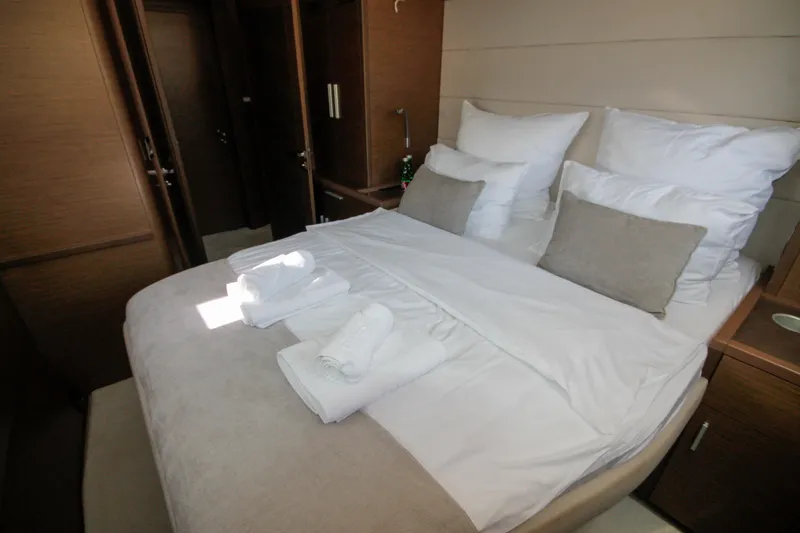  Yacht Photos Pics Luxurious bedroom interior of 2019 Lagoon 620 Essense yacht with neatly arranged bedding.