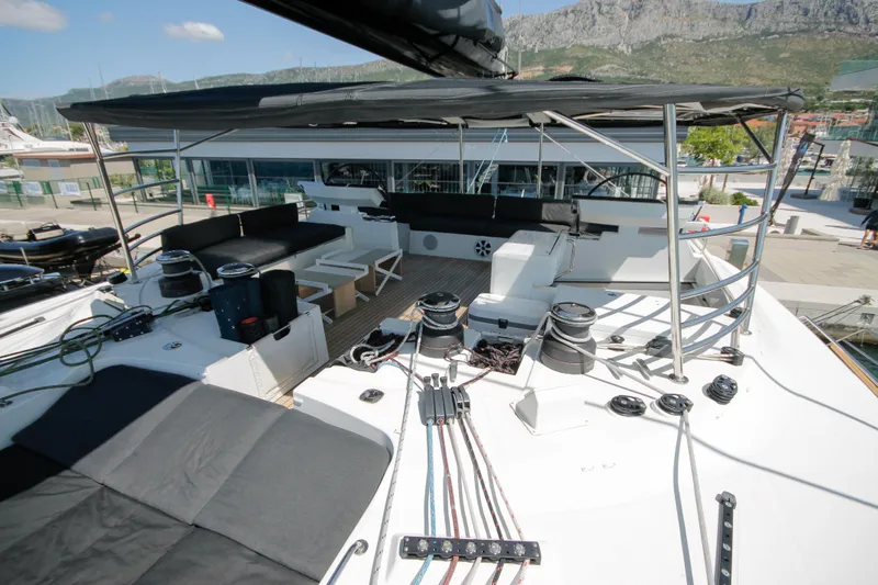  Yacht Photos Pics 2019 Lagoon 620 Essense yacht deck with seating and equipment, docked at marina.