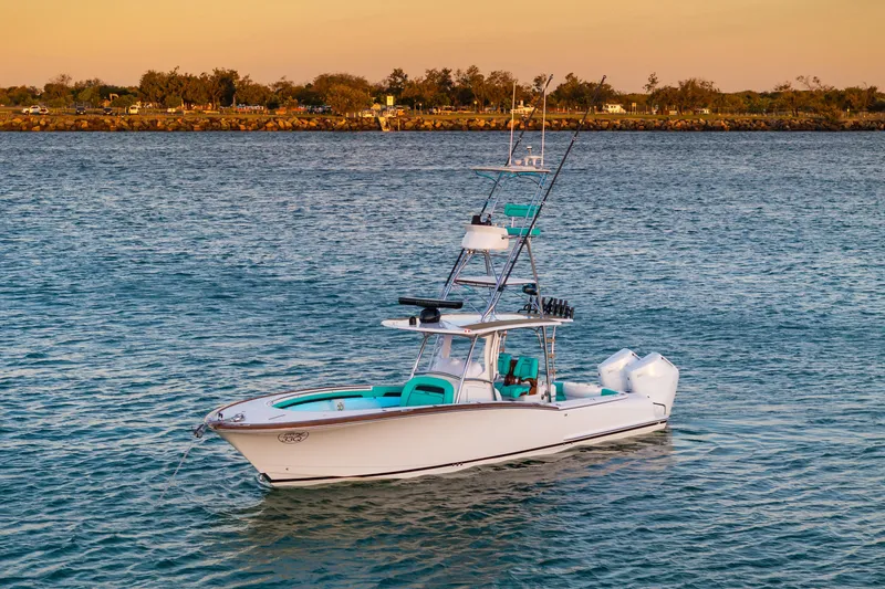 Toto II Yacht Photos Pics 2019 Mag Bay 33 CC boat on calm water at sunset.