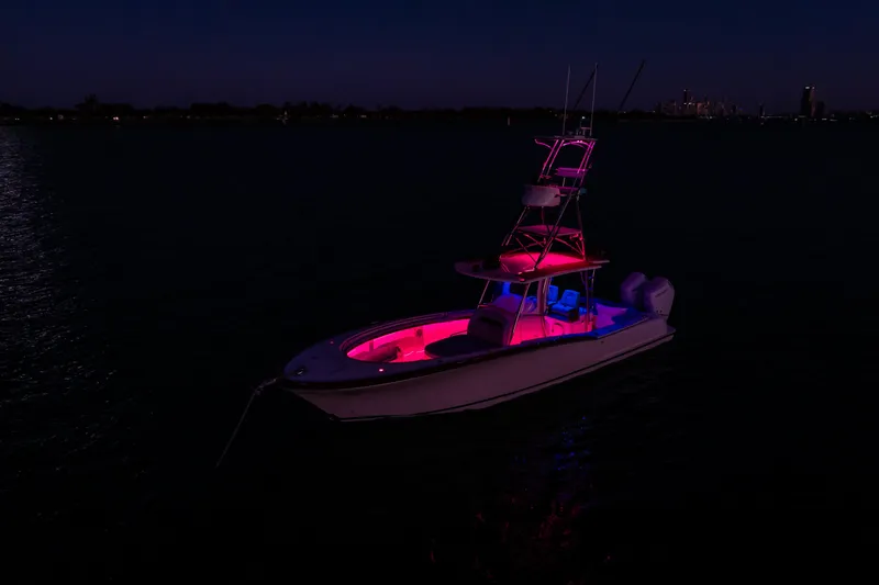Toto II Yacht Photos Pics 2019 Mag Bay 33 CC boat illuminated with vibrant pink and blue lights at night.