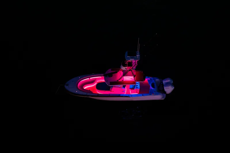 Toto II Yacht Photos Pics 2019 Mag Bay 33 CC boat illuminated with vibrant pink and blue lights at night.