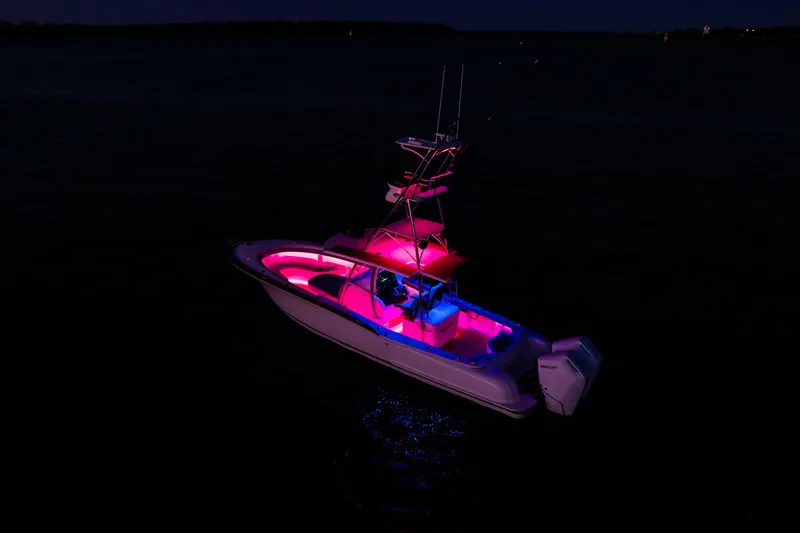 Toto II Yacht Photos Pics 2019 Mag Bay 33 CC boat illuminated with vibrant pink and blue lights at night.
