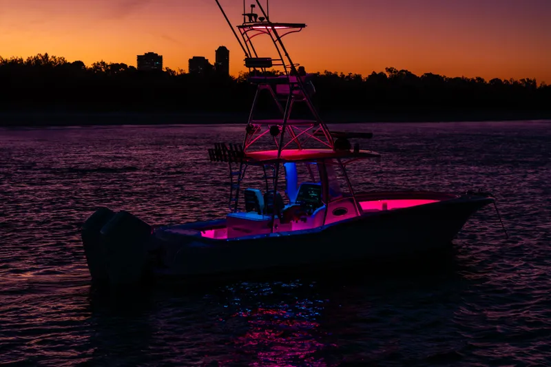 Toto II Yacht Photos Pics 2019 Mag Bay 33 CC boat illuminated at sunset with vibrant pink and blue lights.
