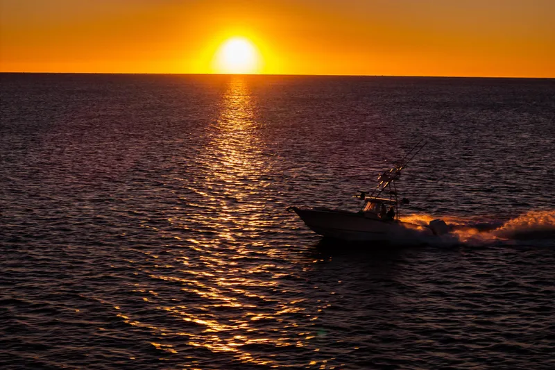 Toto II Yacht Photos Pics 2019 Mag Bay 33 CC boat cruising at sunset on open water.