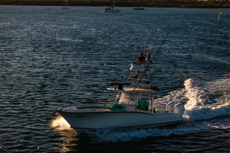 Toto II Yacht Photos Pics 2019 Mag Bay 33 CC boat cruising on open water at sunset.