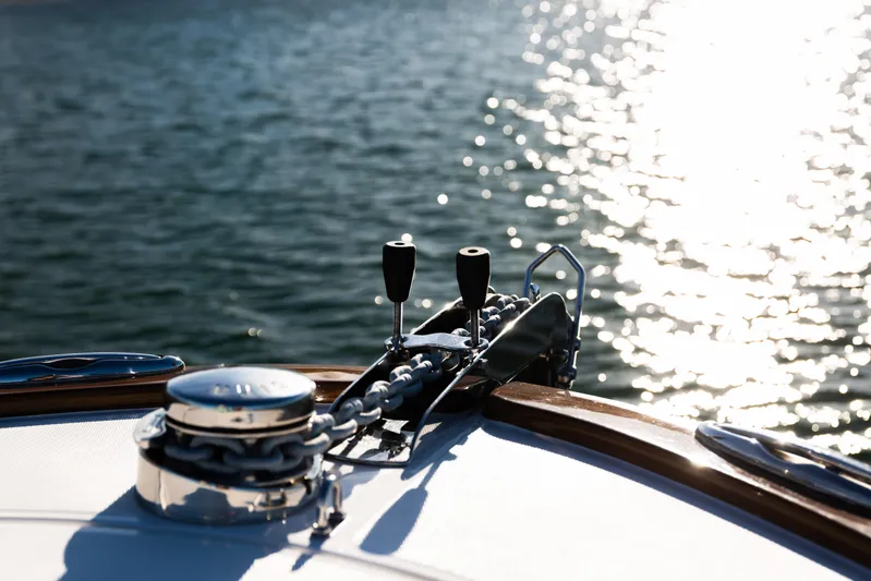 Toto II Yacht Photos Pics Bow of 2019 Mag Bay 33 CC boat with anchor chain, glistening water background.