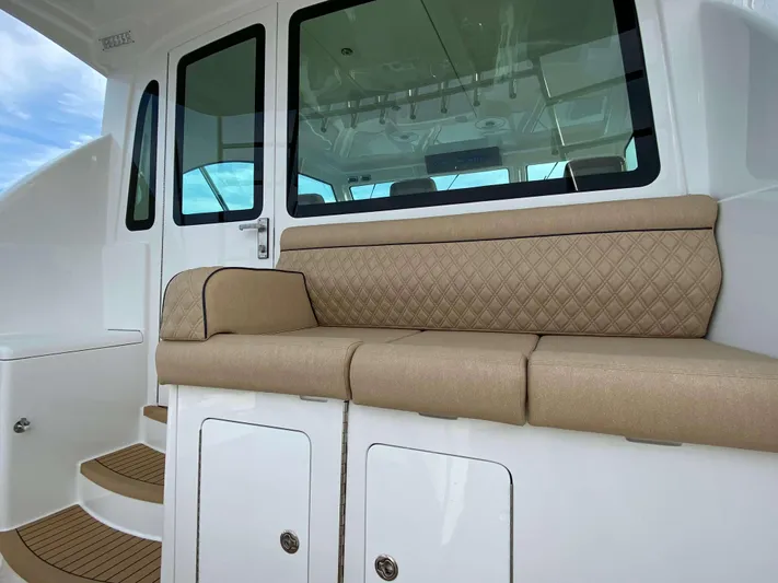  Yacht Photos Pics 2021 Henriques 42 Express Hardtop Bridge interior with beige seating and white cabinetry.
