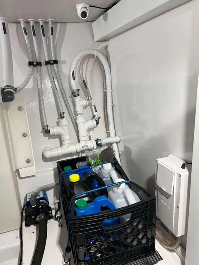  Yacht Photos Pics 2021 Henriques 42 Express Hardtop Bridge engine room with hoses and cleaning supplies.