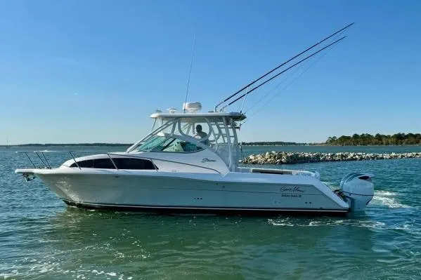 Seanior Moment Yacht Photos Pics 2022 Stamas 370 Aegean boat cruising on a sunny day near rocky shoreline.