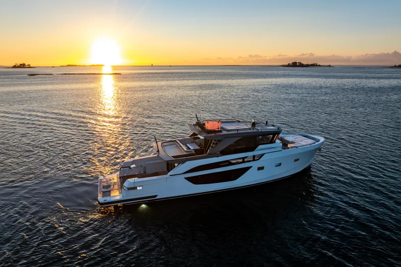 The Calm Down Yacht Photos Pics 2024 Bluegame BGX63 yacht cruising at sunset on serene waters.