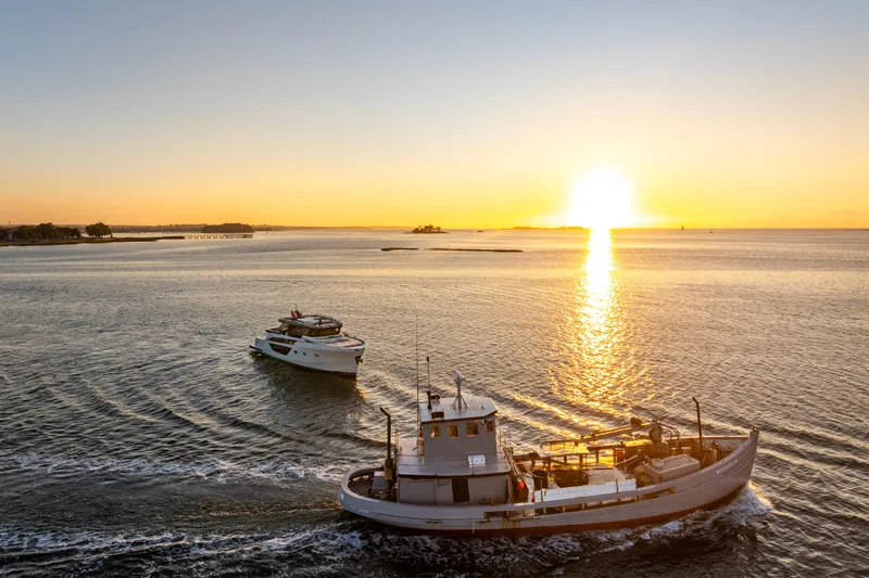 The Calm Down Yacht Photos Pics 2024 Bluegame BGX63 yacht cruising at sunset on open water.