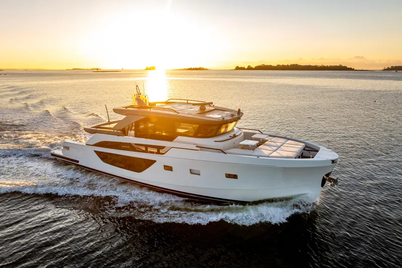 The Calm Down Yacht Photos Pics 2024 Bluegame BGX63 yacht cruising at sunset on open water.