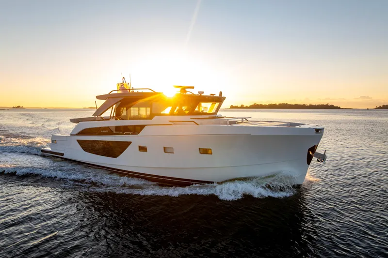 The Calm Down Yacht Photos Pics 2024 Bluegame BGX63 yacht cruising at sunset on open water.